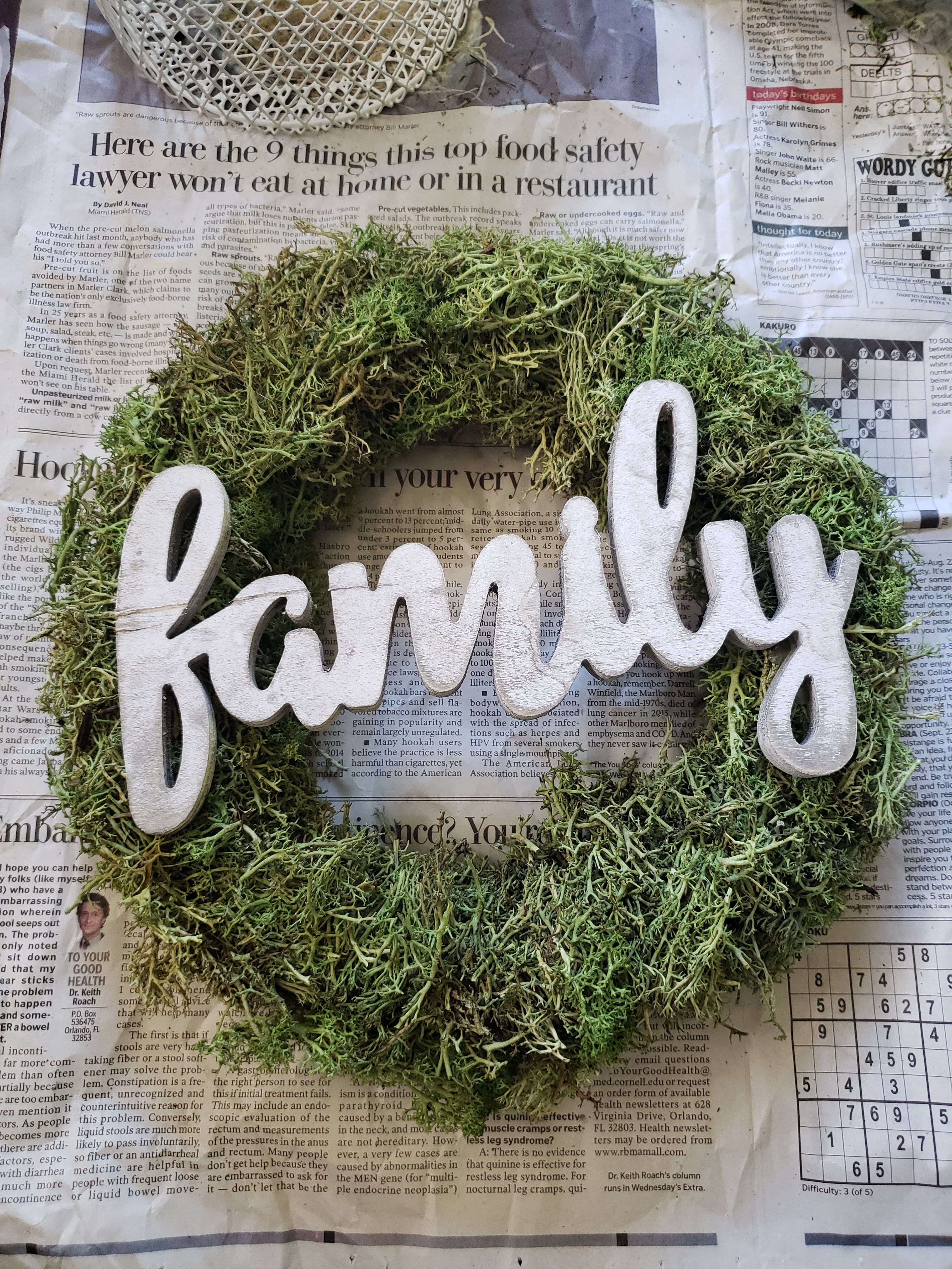 Attach the wood lettering sign to the wreath with hot glue. 
