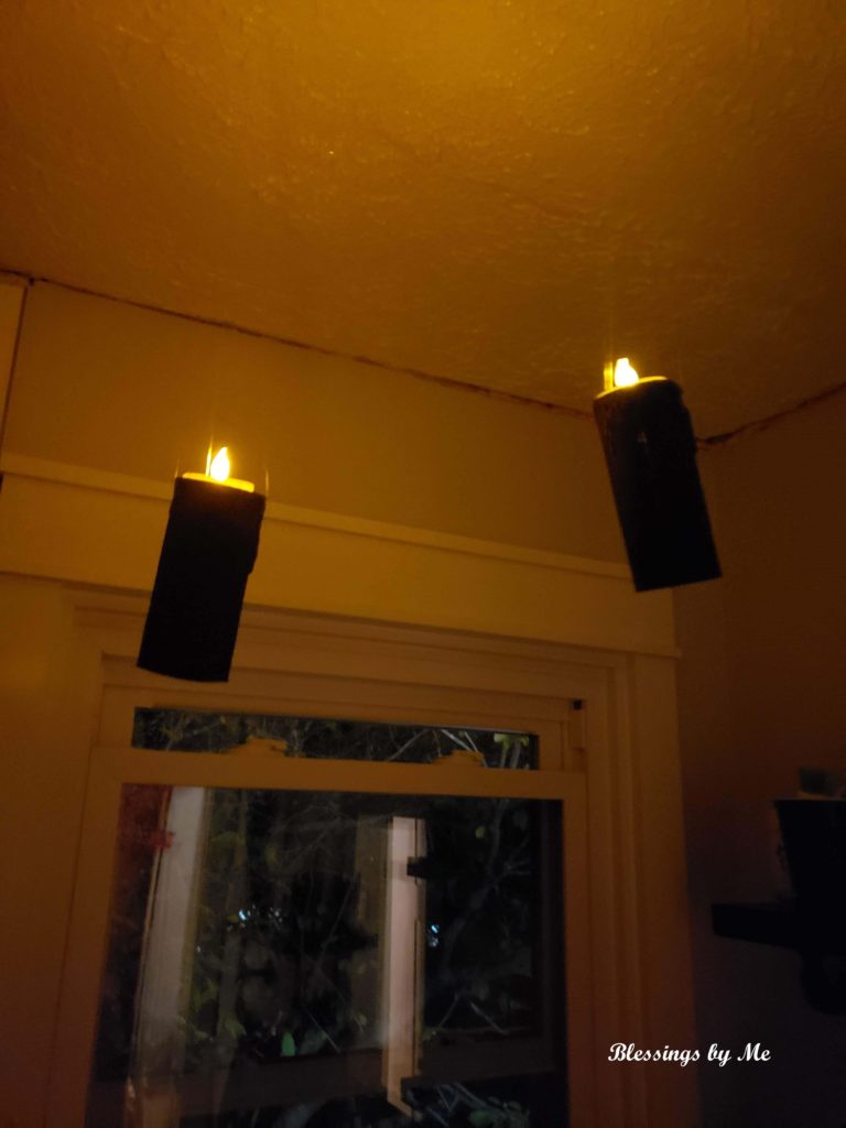 lit candles hanging from ceiling 