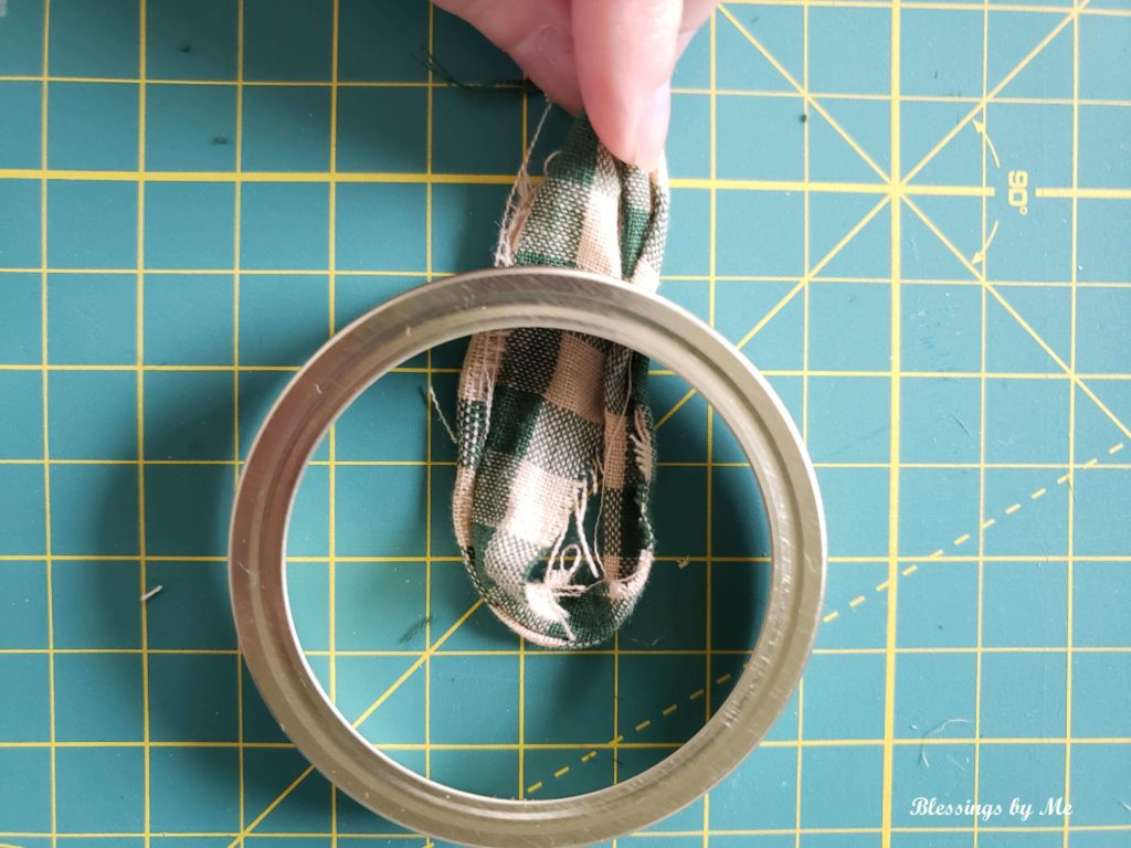 step 3 - put the fabric strip under the edge of the mason jar lid ring